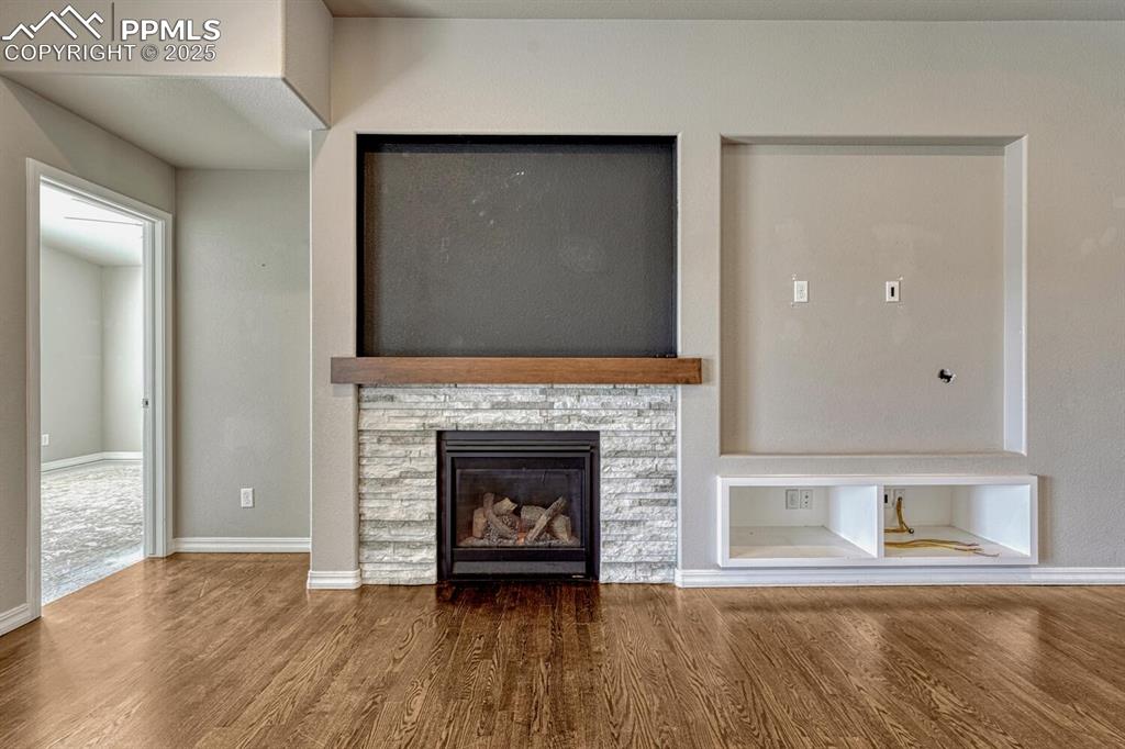 Image 11 of 45: Step into the family room, where a ceiling fan, stone fireplace, and stunni