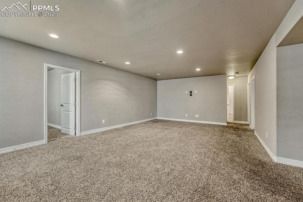Image 20 of 45: Step into our inviting living room, featuring soft carpet floors, a texture