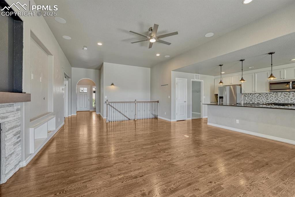Image 7 of 45: Step into the family room, where a ceiling fan, stone fireplace, and stunni
