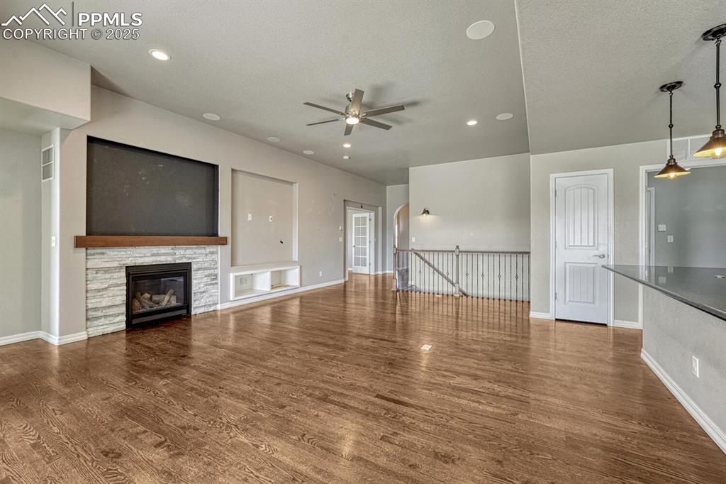 Image 9 of 45: Step into the family room, where a ceiling fan, stone fireplace, and stunni