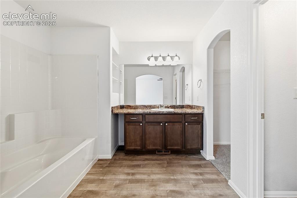 Image 23 of 44: Full bathroom featuring a single vanity with a dark wood-finish cabinet and