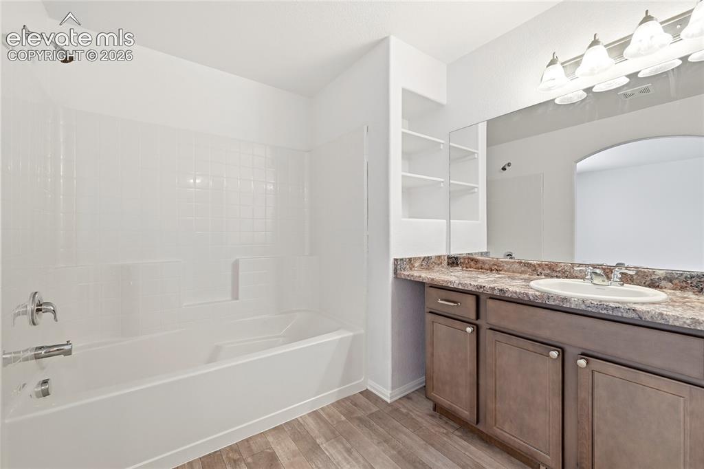 Image 24 of 44: Bathroom featuring a built-in tub and shower combination with white subway 
