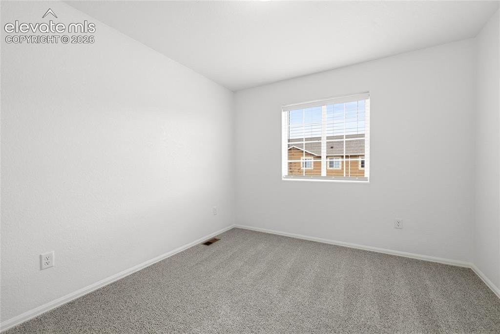 Image 27 of 44: Bright room featuring white painted walls and gray carpet flooring