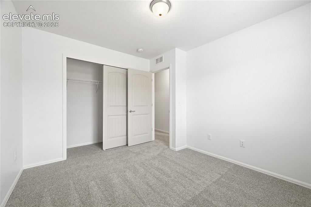 Image 28 of 44: Spacious room featuring light gray carpeting and white walls
