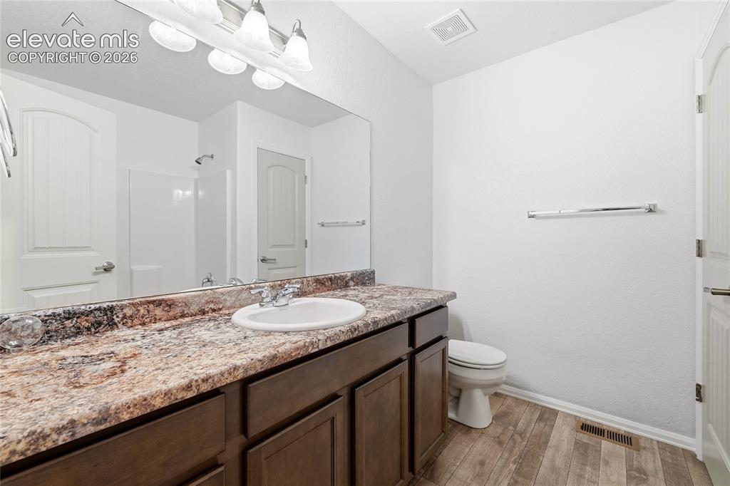 Image 31 of 44: Bathroom featuring a vanity with a prominent countertop, an integrated sink