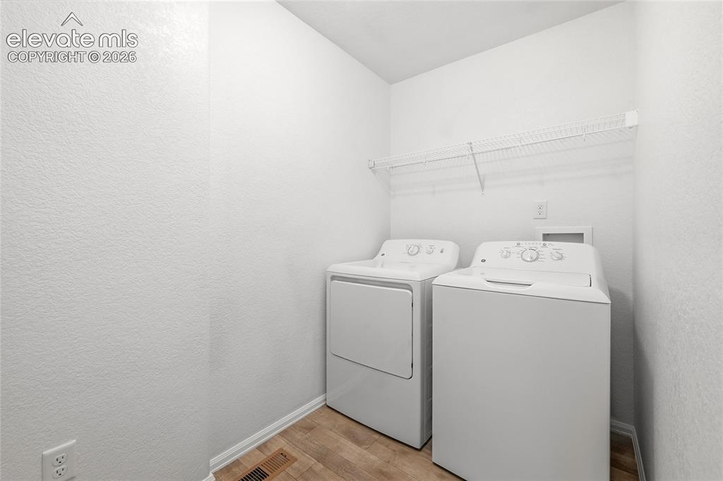 Image 32 of 44: Laundry area featuring a top-load washing machine, a front-load dryer, and 
