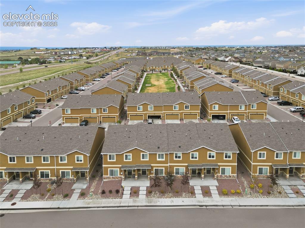 Image 37 of 44: Aerial perspective showcasing a community of townhomes featuring warm earth