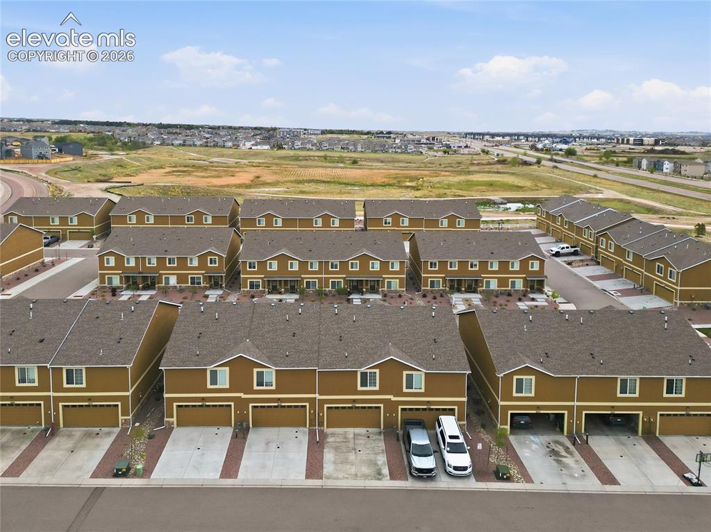 Image 39 of 44: Aerial perspective showcasing a collection of townhomes featuring brown sid