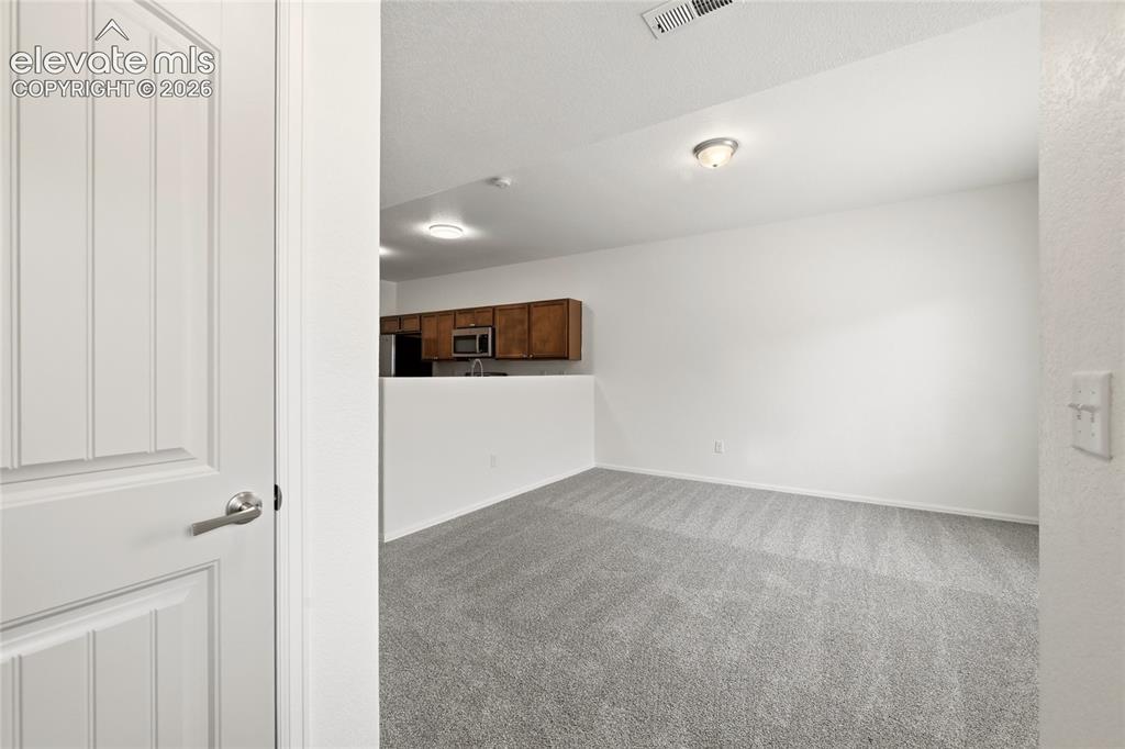 Image 5 of 44: Neutral tone interior with light gray carpet and white walls