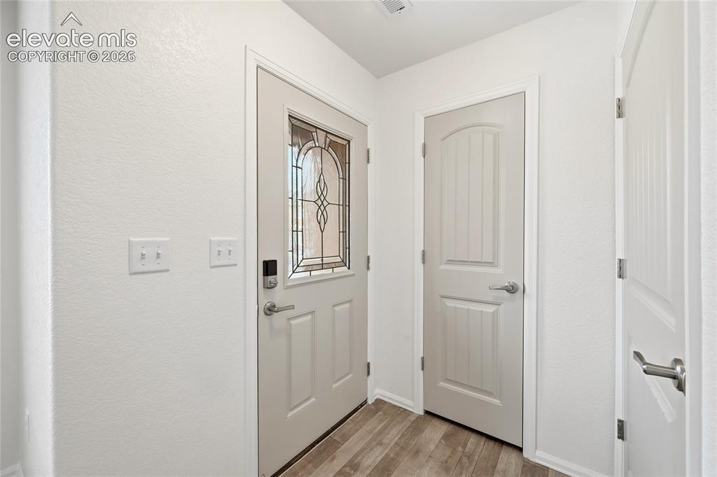Image 6 of 44: Entryway featuring a decorative glass panel door with smart lock hardware, 