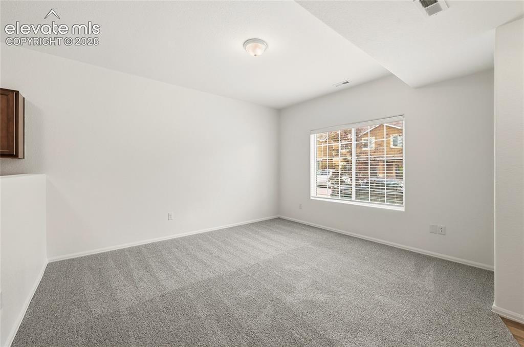 Image 9 of 44: Spacious room featuring light gray carpeting, neutral wall finishes, a larg