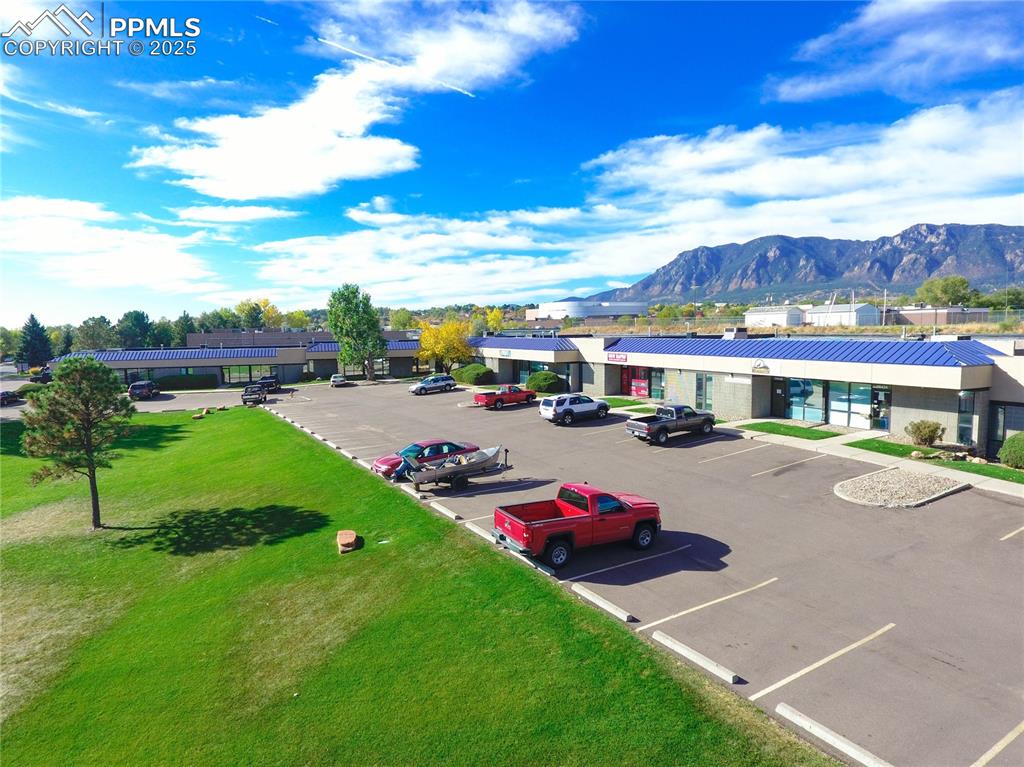 Image 1 of 31: View of parking / parking lot with a mountain view and a yard