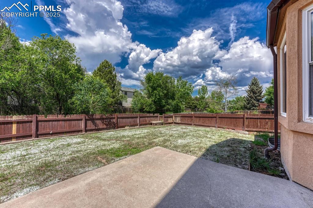 Image 17 of 40: View of the beautifully landscaped backyard from the patio.