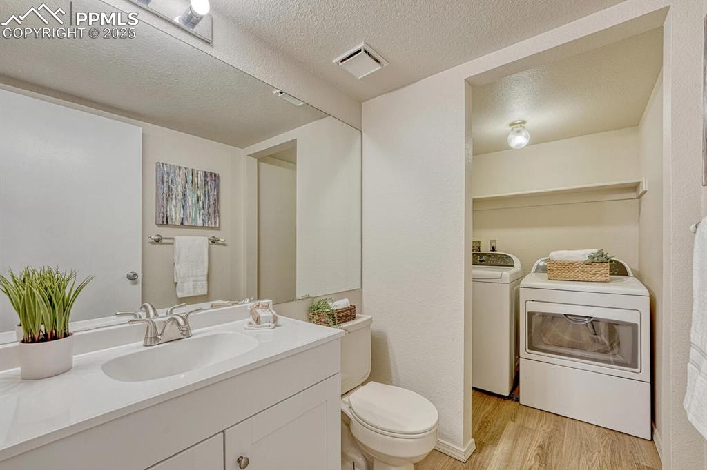 Image 20 of 40: Main level Powder Bathroom with new vanity, mirror, and laundry area with w