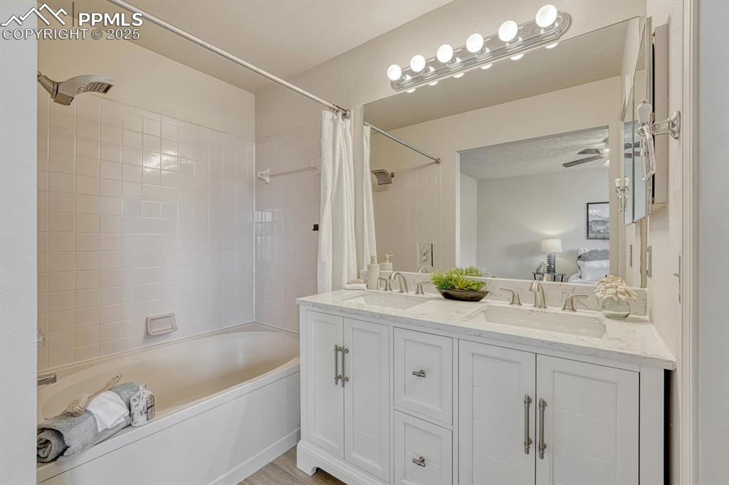 Image 25 of 40: The Upper Level Primary Bathroom offers a new vanity, mirror, and tiled tub