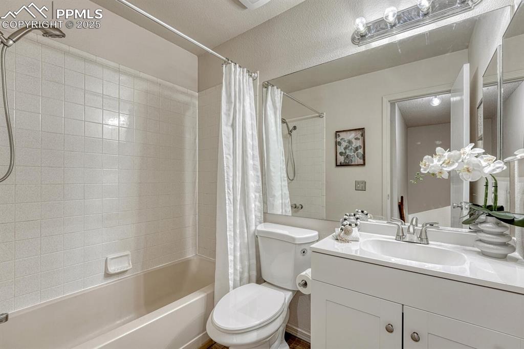 Image 28 of 40: Upper Level Full Bathroom with new vanity, mirror, and tiled tub/shower.