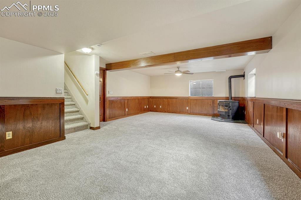 Image 31 of 40: Basement Recreation Room with wood wainscoting, new carpet, a lighted ceili