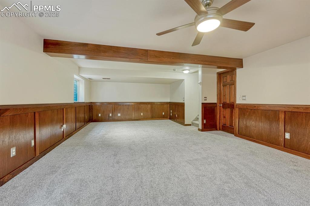 Image 33 of 40: Basement Recreation Room and door into a large unfinished space that can pr