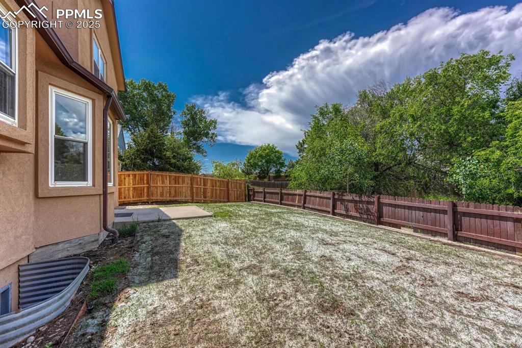 Image 36 of 40: Meticulous, fenced backyard with mature trees for privacy and stunning moun