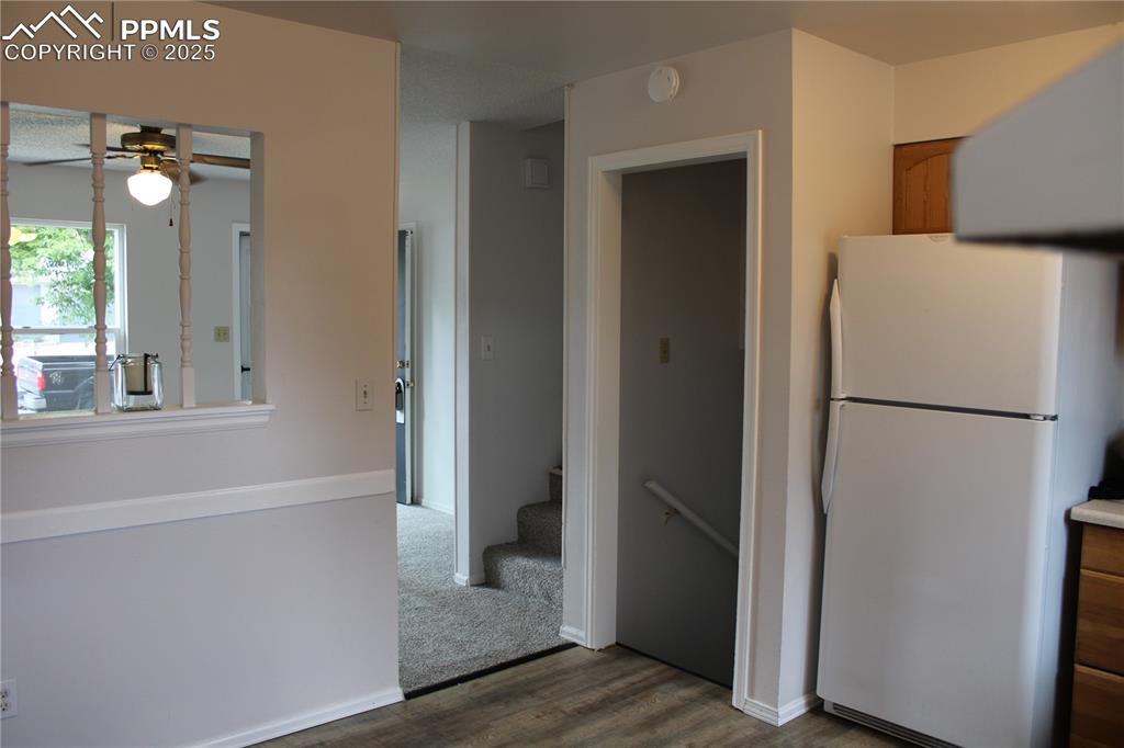Image 10 of 35: Kitchen with freestanding refrigerator, brown cabinetry, a ceiling fan, and