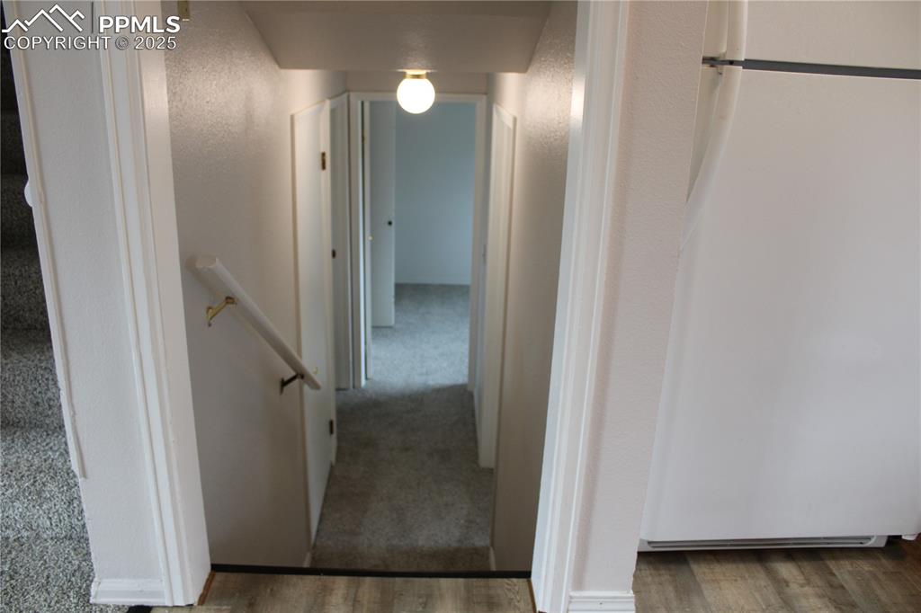 Image 11 of 35: Hallway with an upstairs landing and wood finished floors
