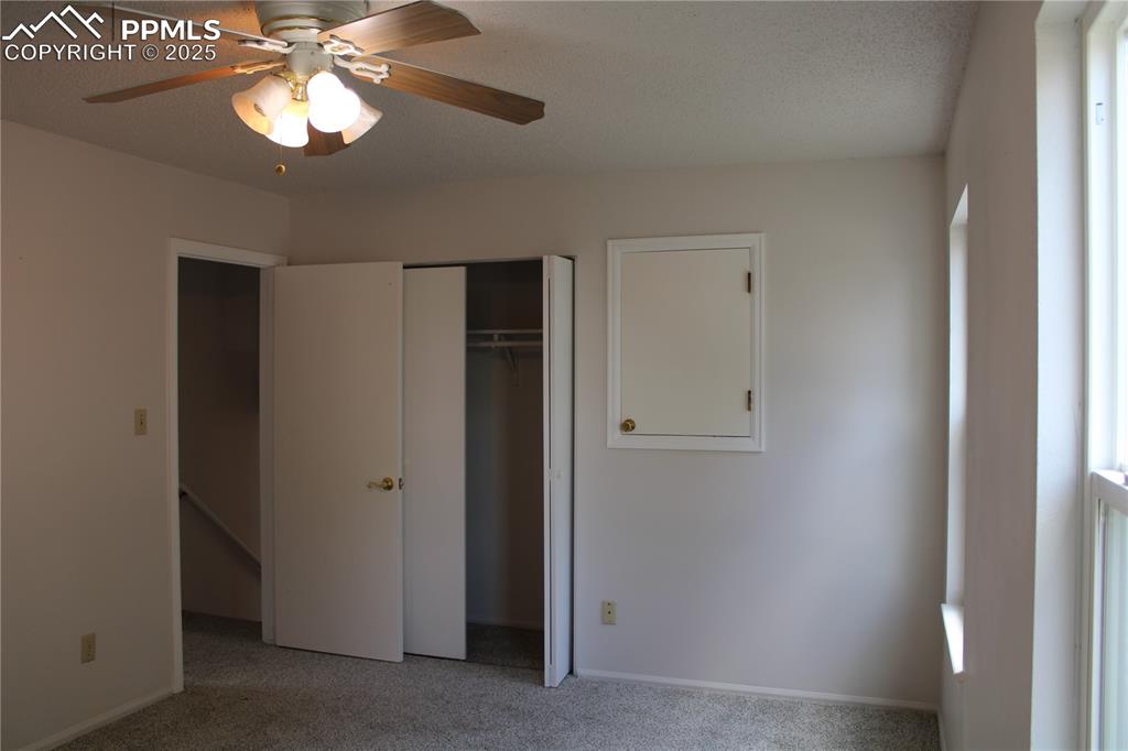 Image 16 of 35: Unfurnished bedroom featuring light carpet, a ceiling fan, a closet, a text