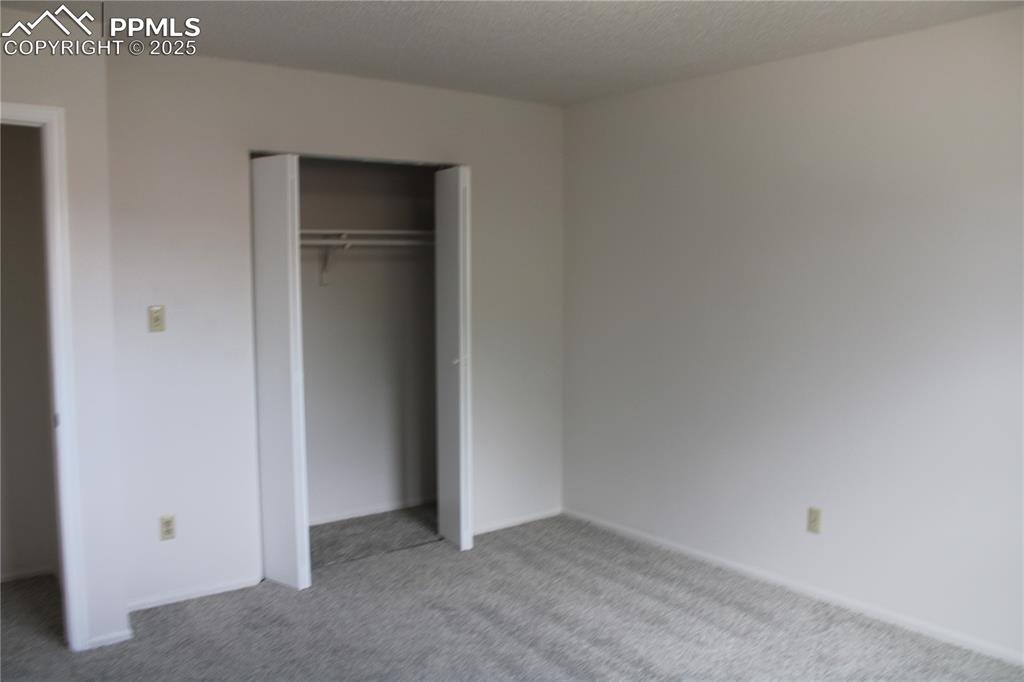 Image 19 of 35: Unfurnished bedroom with carpet floors, a textured ceiling, and a closet