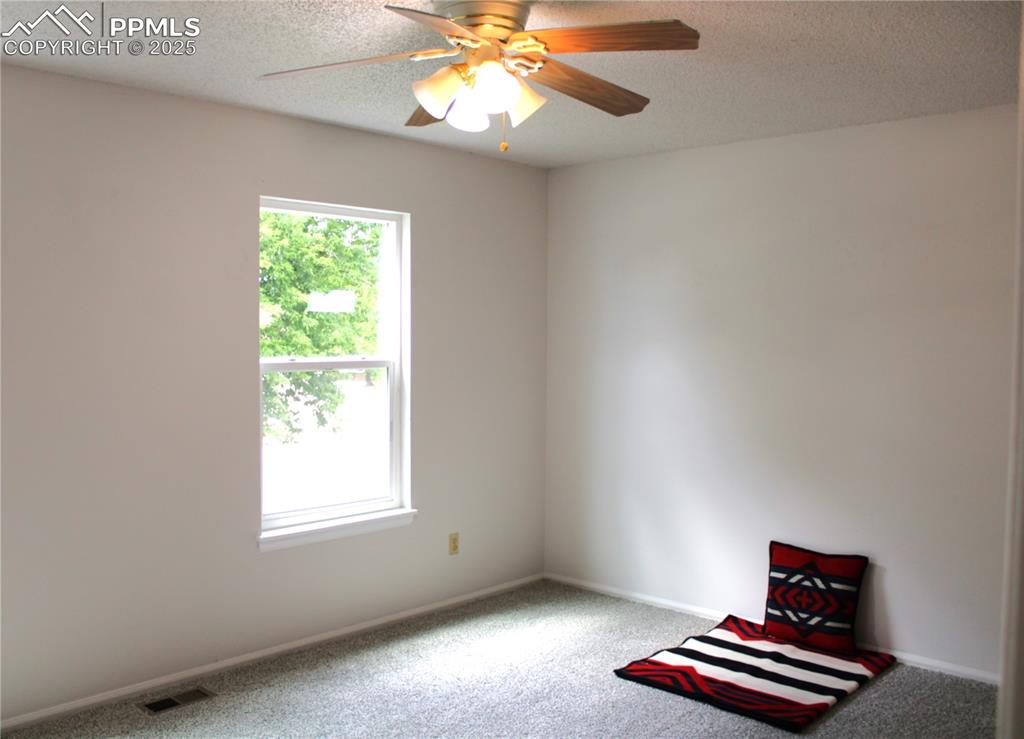 Image 22 of 35: Carpeted spare room featuring a textured ceiling and a ceiling fan