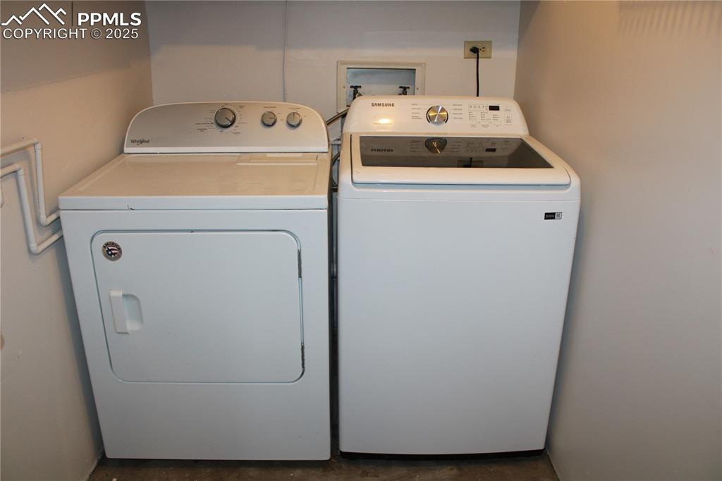 Image 23 of 35: Washroom featuring washing machine and clothes dryer