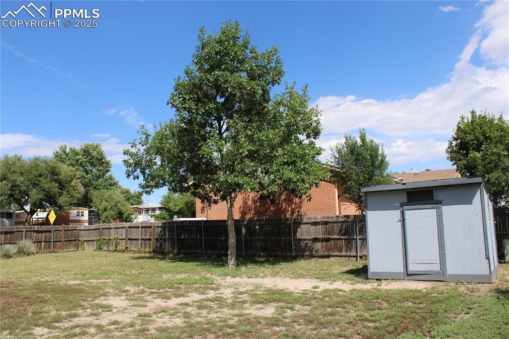 Image 24 of 35: Fenced backyard with a storage shed