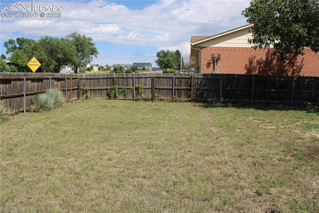Image 27 of 35: View of large fenced backyard