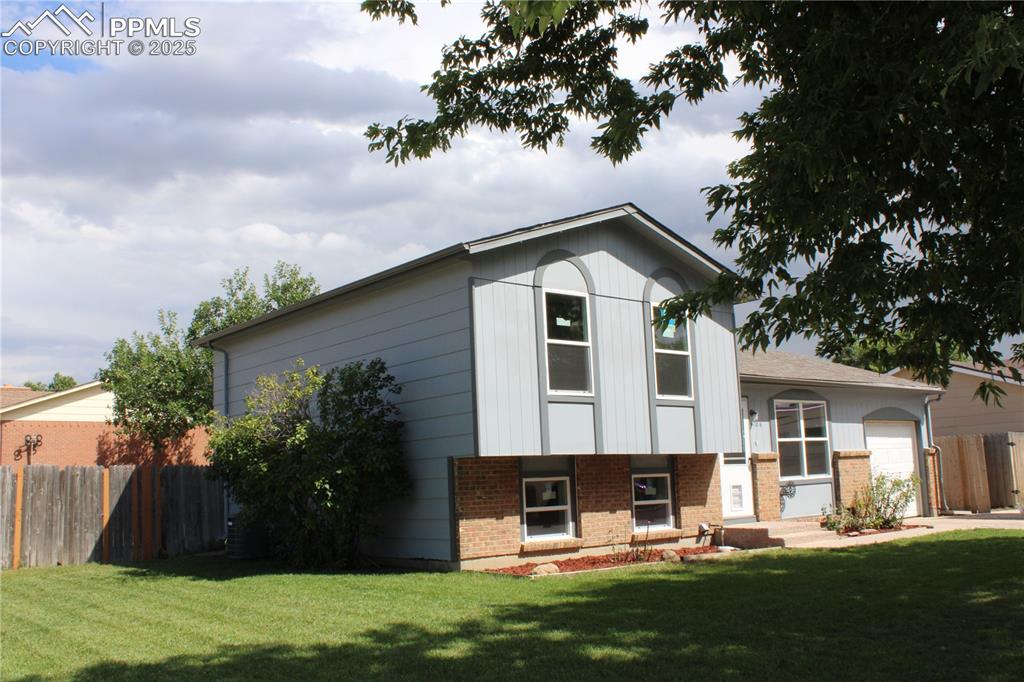 Image 3 of 35: Tri-level home featuring brick siding and an attached garage