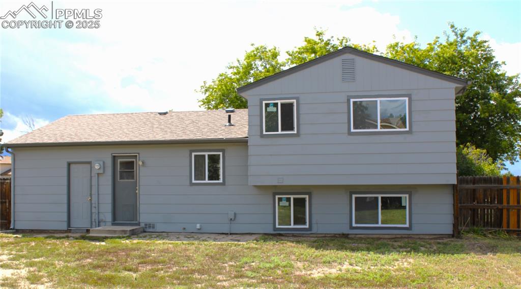 Image 32 of 35: Back of house featuring a shingled roof