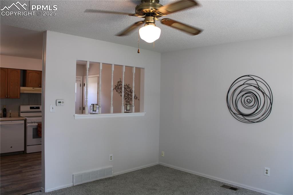 Image 5 of 35: Living room with carpet flooring, a textured ceiling, and a ceiling fan