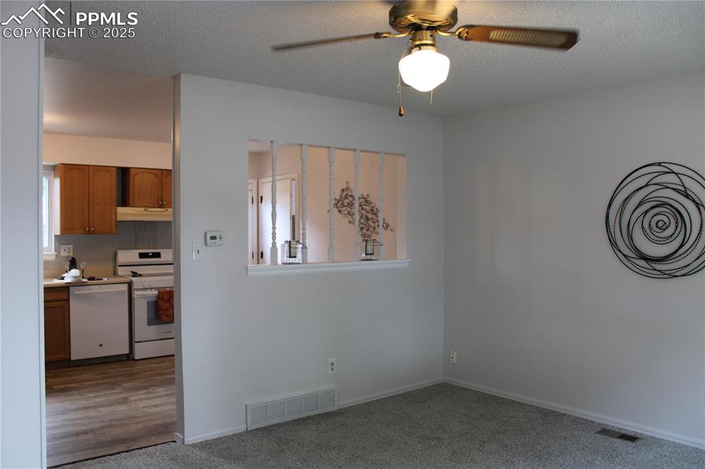 Image 6 of 35: Living room featuring carpet flooring, a textured ceiling, and ceiling fan