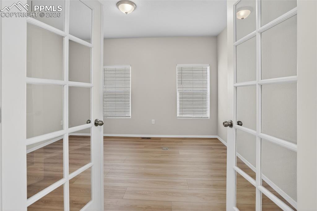 Image 14 of 44: Interior space featuring wood-finish flooring, light gray walls, and white 