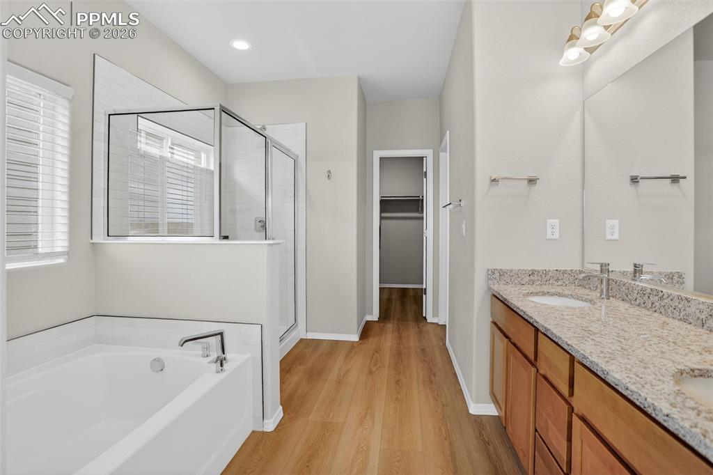Image 20 of 44: Spacious room featuring wood-finish flooring, a contemporary ceiling fan wi