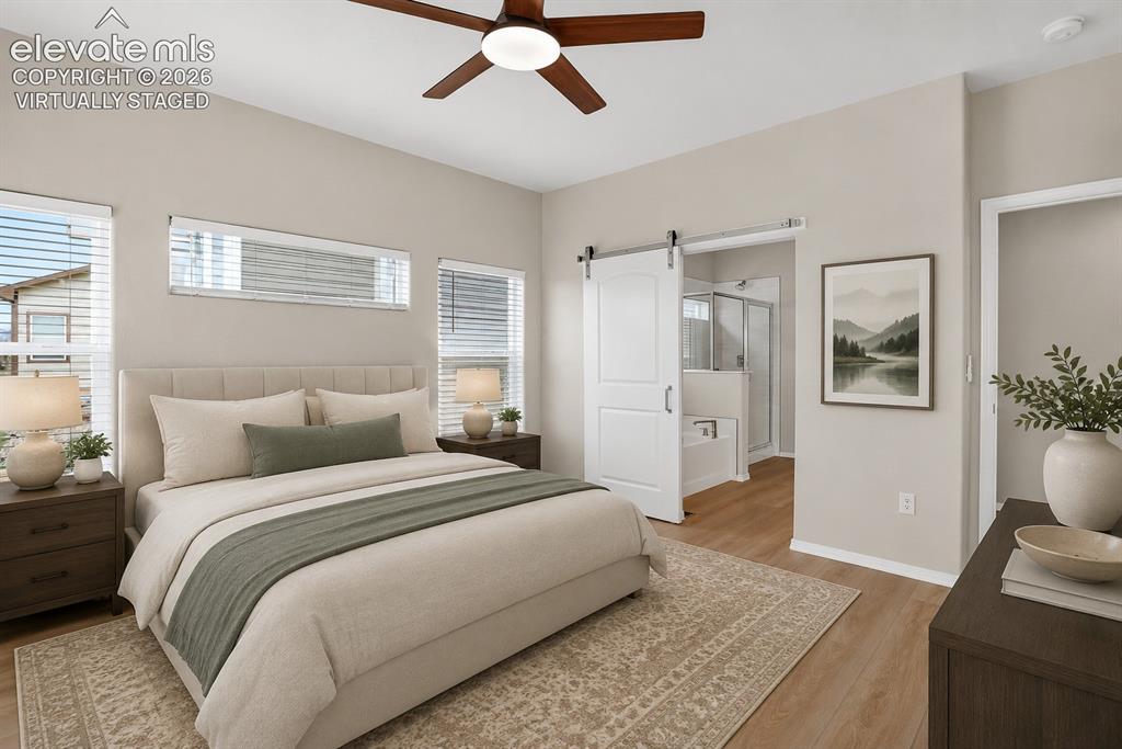 Image 20 of 49: Spacious room featuring wood-finish flooring, a contemporary ceiling fan, m