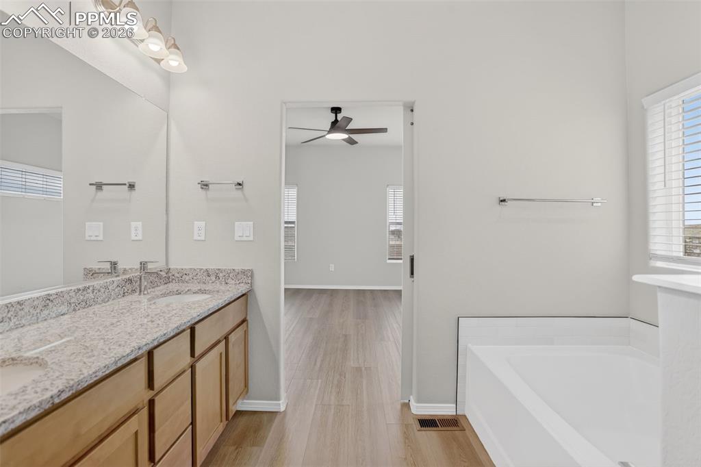 Image 21 of 44: Neutral-toned room featuring wood-finish flooring and a ceiling fan with in
