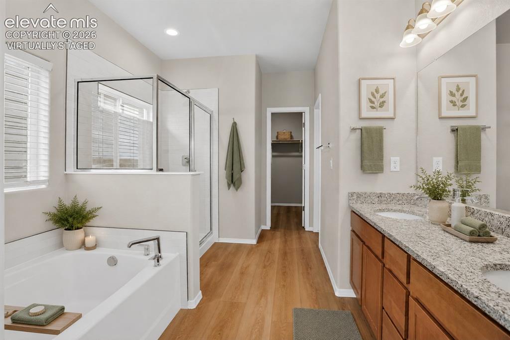 Image 23 of 49: Bathroom featuring a dual-sink vanity with a granite-style countertop, wood