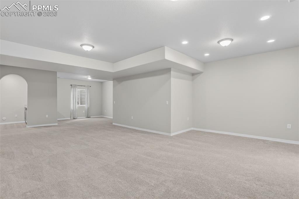 Image 27 of 44: Spacious room featuring neutral carpet flooring, recessed lighting, and a p