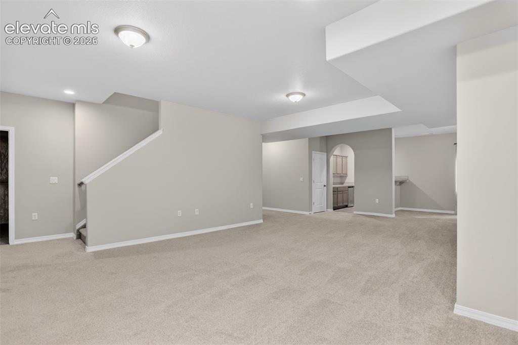 Image 28 of 49: Spacious room featuring neutral carpet flooring, recessed lighting, and a p