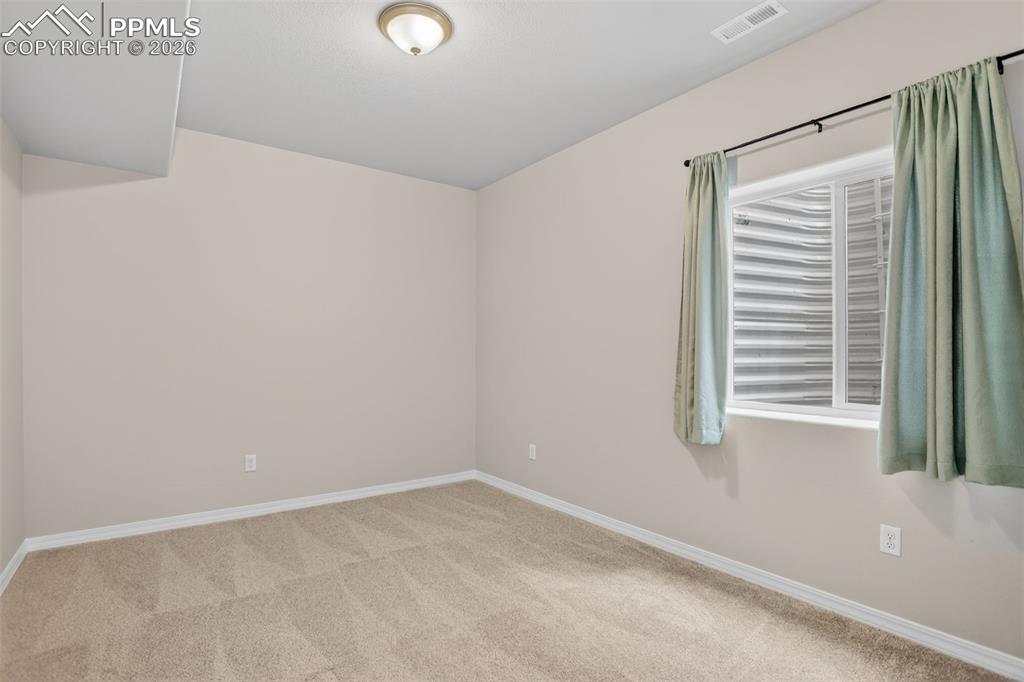 Image 32 of 44: Carpeted room featuring light beige walls, a built-in closet with white bi-