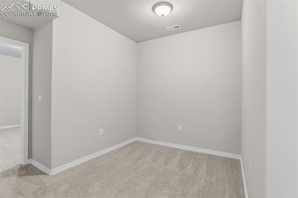 Image 34 of 44: Carpeted room featuring a white-framed window with a horizontal grate, neut