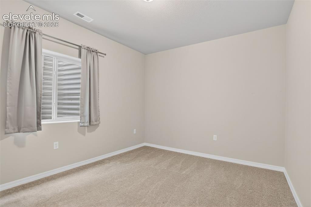 Image 34 of 49: Neutral-toned room featuring a single window with a privacy screen, light b