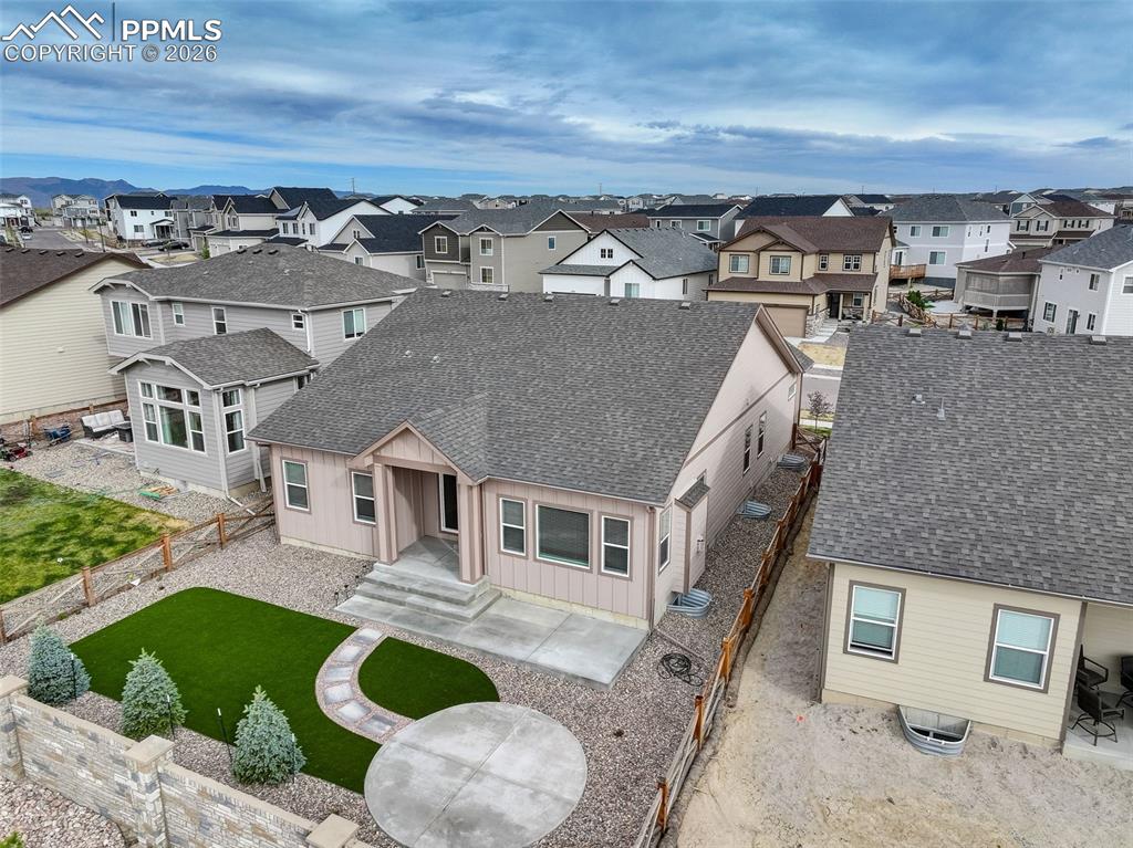 Image 37 of 44: Rear exterior featuring a concrete patio, stone pathway, and artificial tur