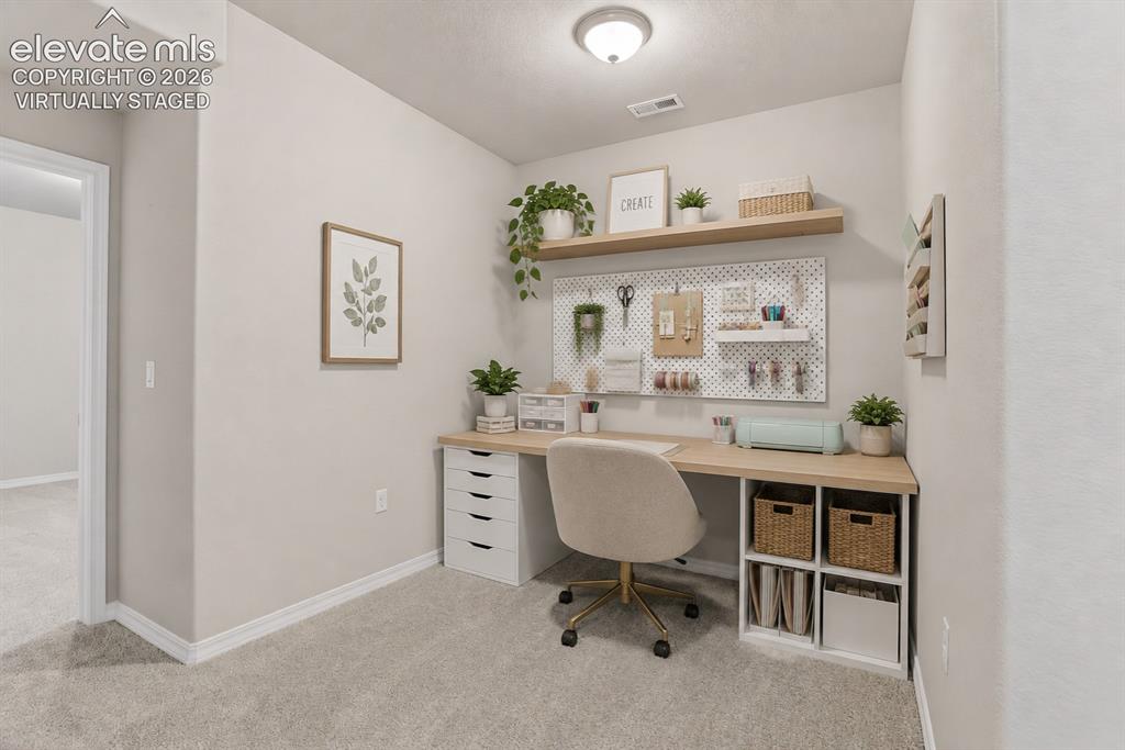 Image 40 of 49: Dedicated office space featuring a built-in wood-finish desk, white base ca
