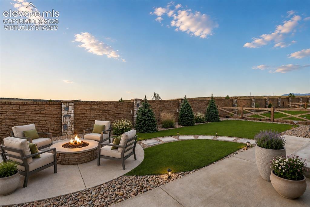 Image 45 of 49: Expansive outdoor area featuring a patterned concrete patio, decorative gra