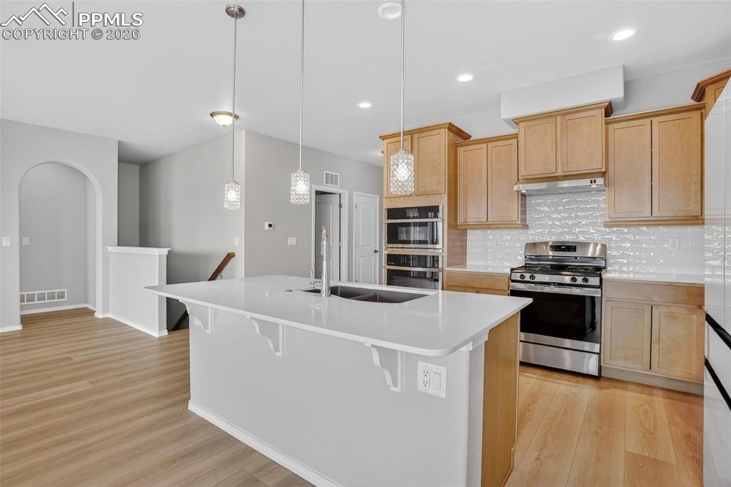 Image 7 of 44: Kitchen featuring a large central island with a double basin sink and a goo