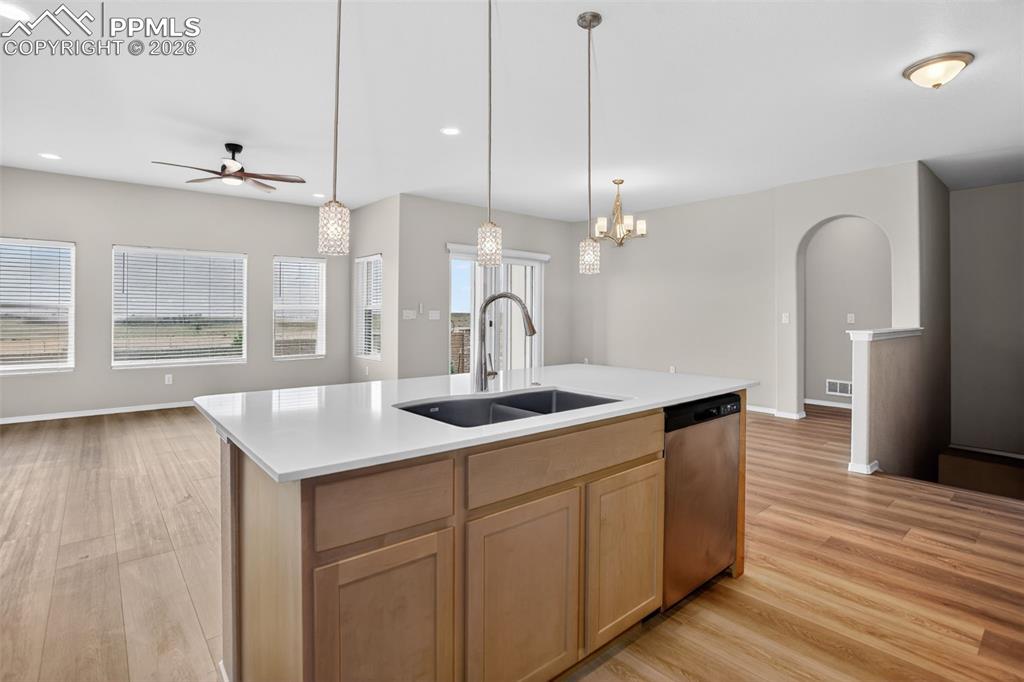 Image 8 of 44: Open-concept kitchen featuring light wood-finish cabinetry, a white subway 